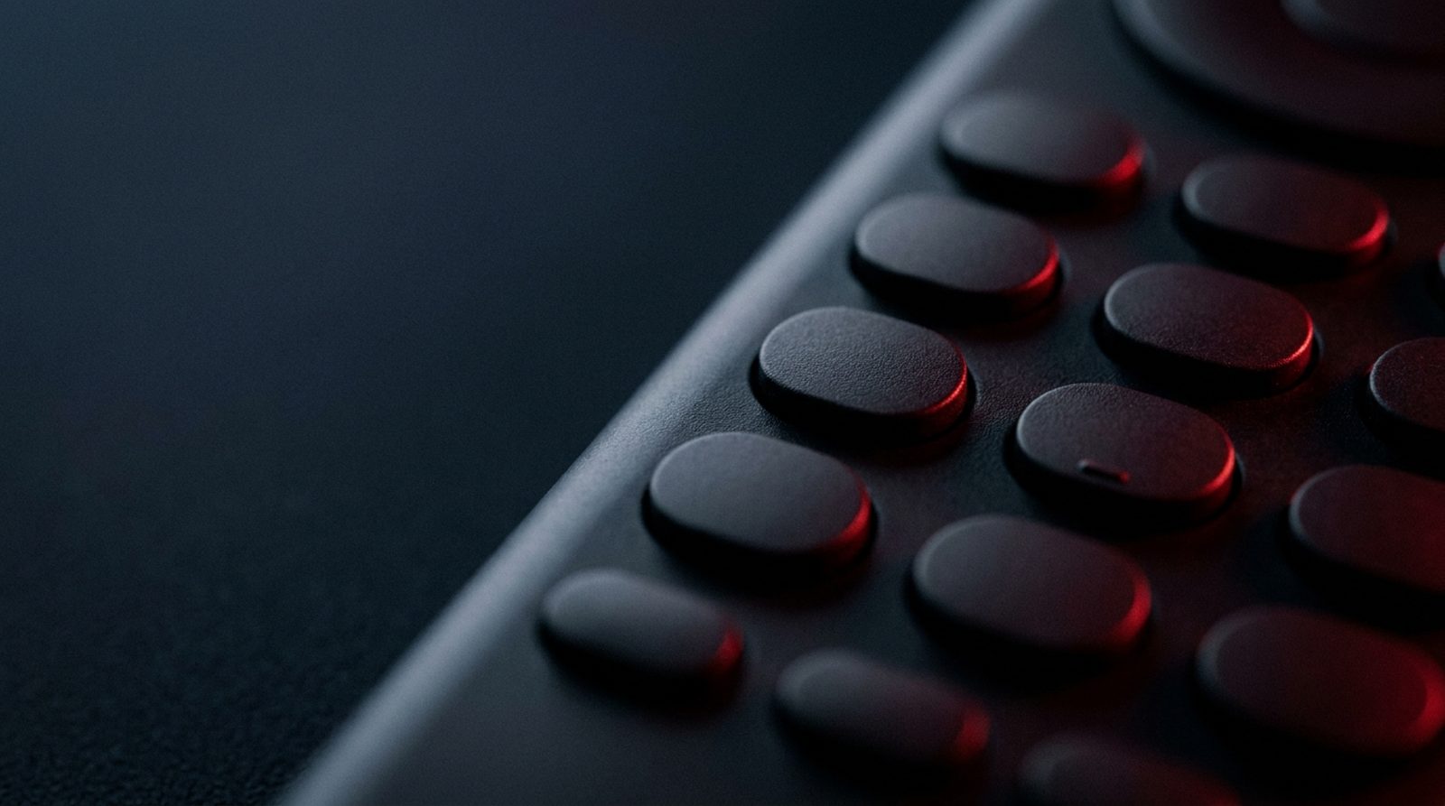 Entering an IPTV Smarters downloader code on a remote control keypad lit in red